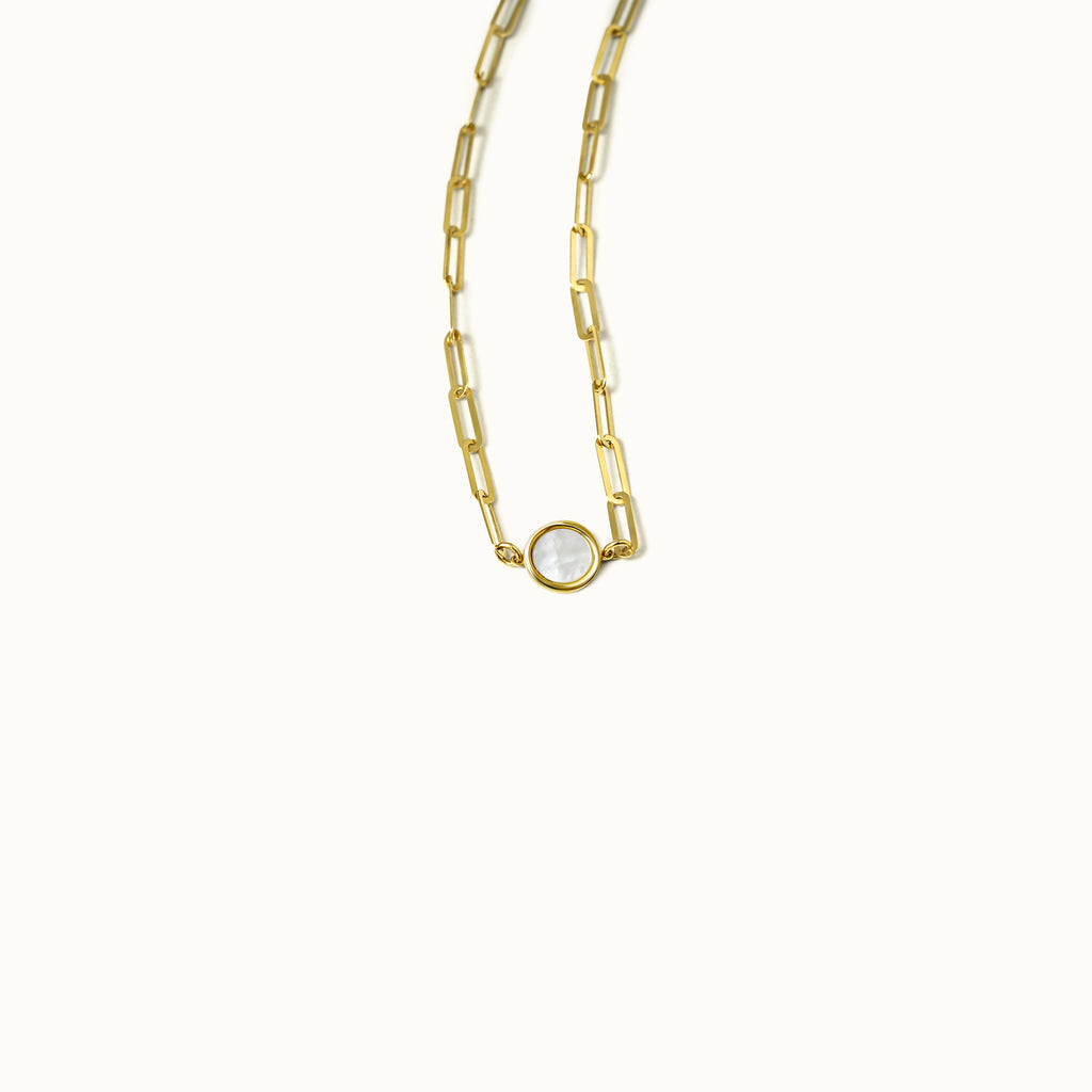 Close-up of round mother-of-pearl pendant set in 18K gold rectangular chain necklace