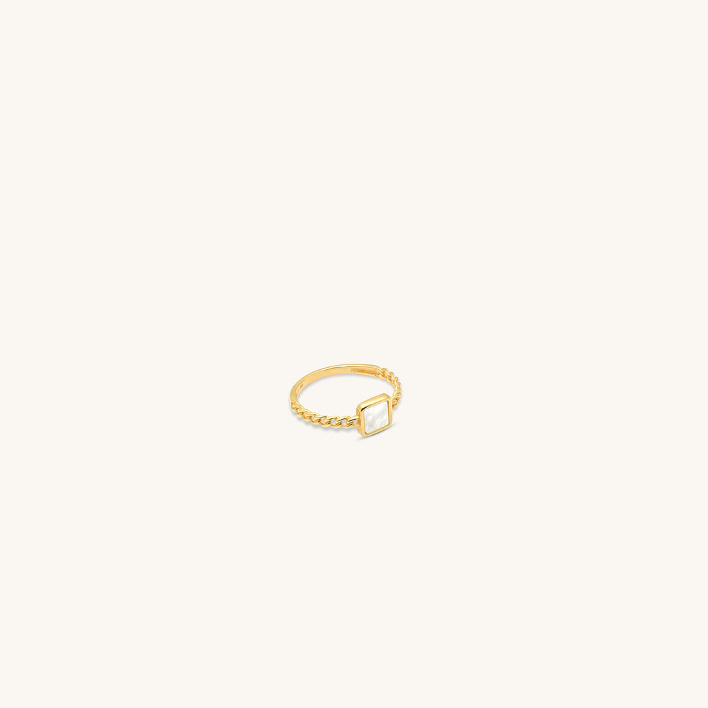 Angled view of 18k gold ring featuring square mother of pearl and twisted band