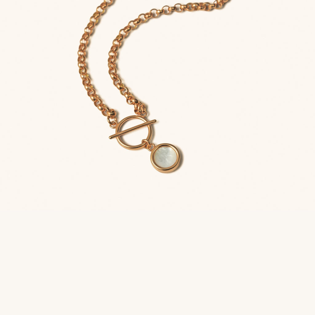 Close-up of 18K rose gold interlocked ring pendant with mother-of-pearl inlay