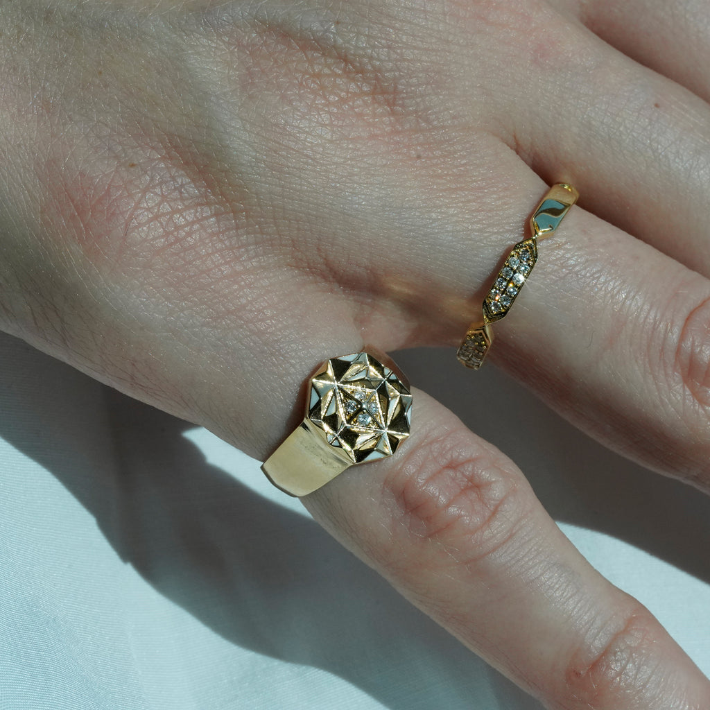 A women wearing diamond rings with gold detailing, displayed against a white background