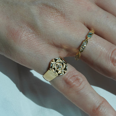 A women wearing diamond rings with gold detailing, displayed against a white background