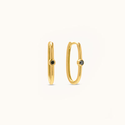 Front view of sleek 18K yellow gold hoop earrings featuring treated black natural diamonds set at the center