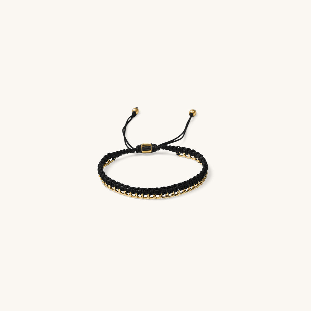 An 18k gold bracelet for women with black threads, featuring an adjustable sliding knot closure placed in a white background