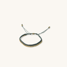 Load image into Gallery viewer, An  18k gold bracelet for women with intertwined grey threads, featuring a fully adjustable design placed in a white background
