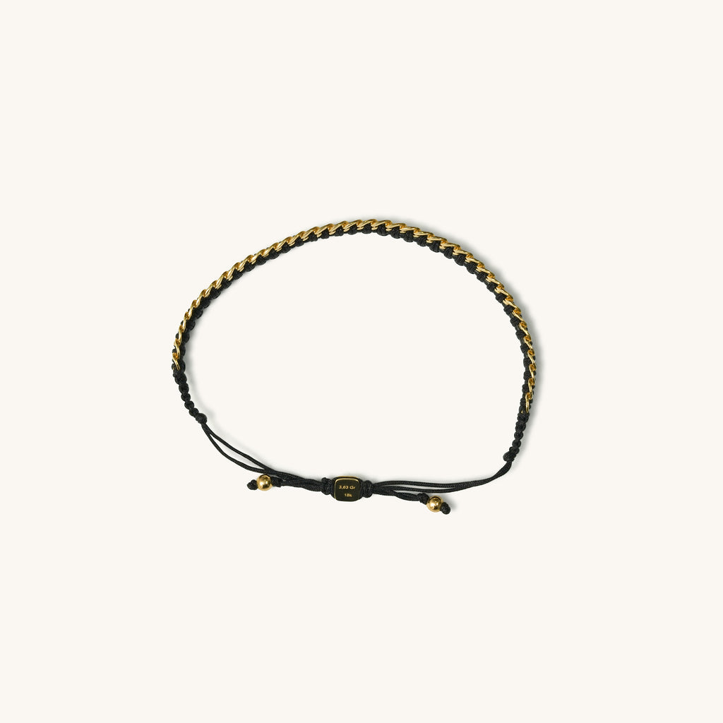 A top view of 18k gold bracelet for women with black threads, featuring an adjustable sliding knot closure