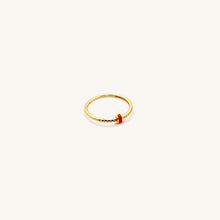 Load image into Gallery viewer, A sleek 18k gold ring with a polished band, accented by a central strip of coral enamel and intricate engravings, place in a white background