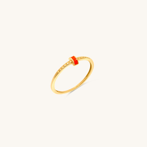 A sleek 18k gold ring with a polished band, accented by a central strip of coral enamel and intricate engravings.