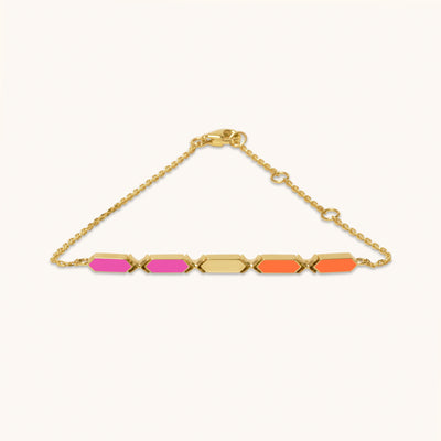 An 18k gold bracelet with vibrant orange and pink facets positioned on a chain, designed to catch light and attention.