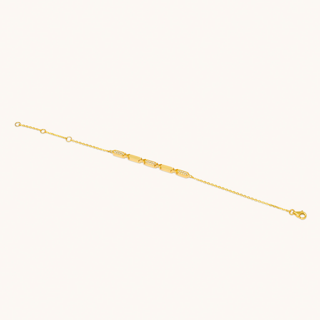 A diamond bracelet with gold chain and diamond segments, featuring a series of diamond pendants aligned in a row.