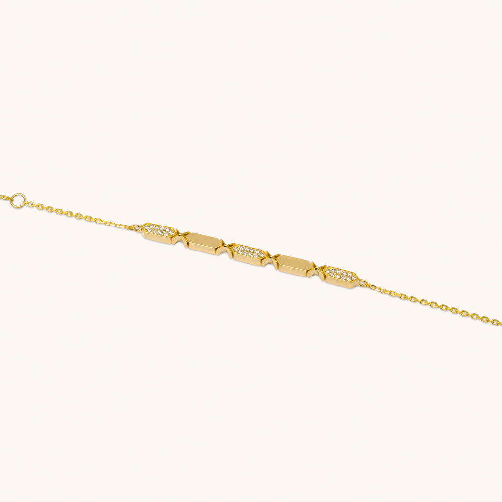 A diamond bracelet with gold chain and diamond segments, featuring a series of diamond pendants aligned in a row. a facets collection from joubijoux