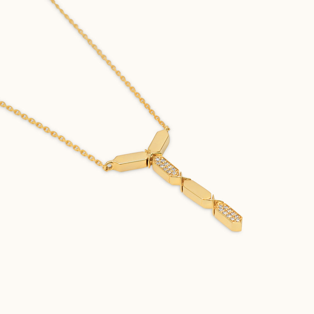A sleek 18k gold and diamond necklace with precision-cut diamonds in a geometric shape with a hint of sparkle, displayed against a white background.