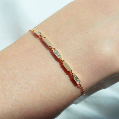 a women wearing a facets  diamond bracelet from joubijoux with gold chain and diamond segments, featuring a series of diamond pendants aligned in a row.