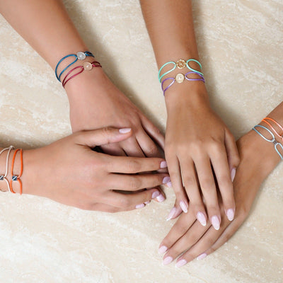 Joubijoux gold bracelet worn on wrist featuring 18K white gold Kaleido cubic design with VS diamond and orange adjustable cord