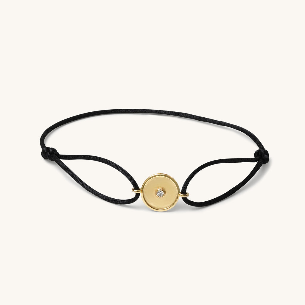 18K yellow gold bracelet by Joubijoux with barrel-inspired center design and single diamond on adjustable black thread