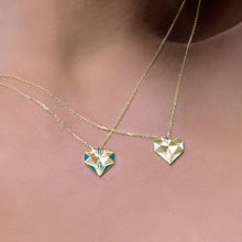 Load image into Gallery viewer, Worn view of Joubijoux gold necklace design showcasing 18K heart diamond pendant with white enamel on model neckline