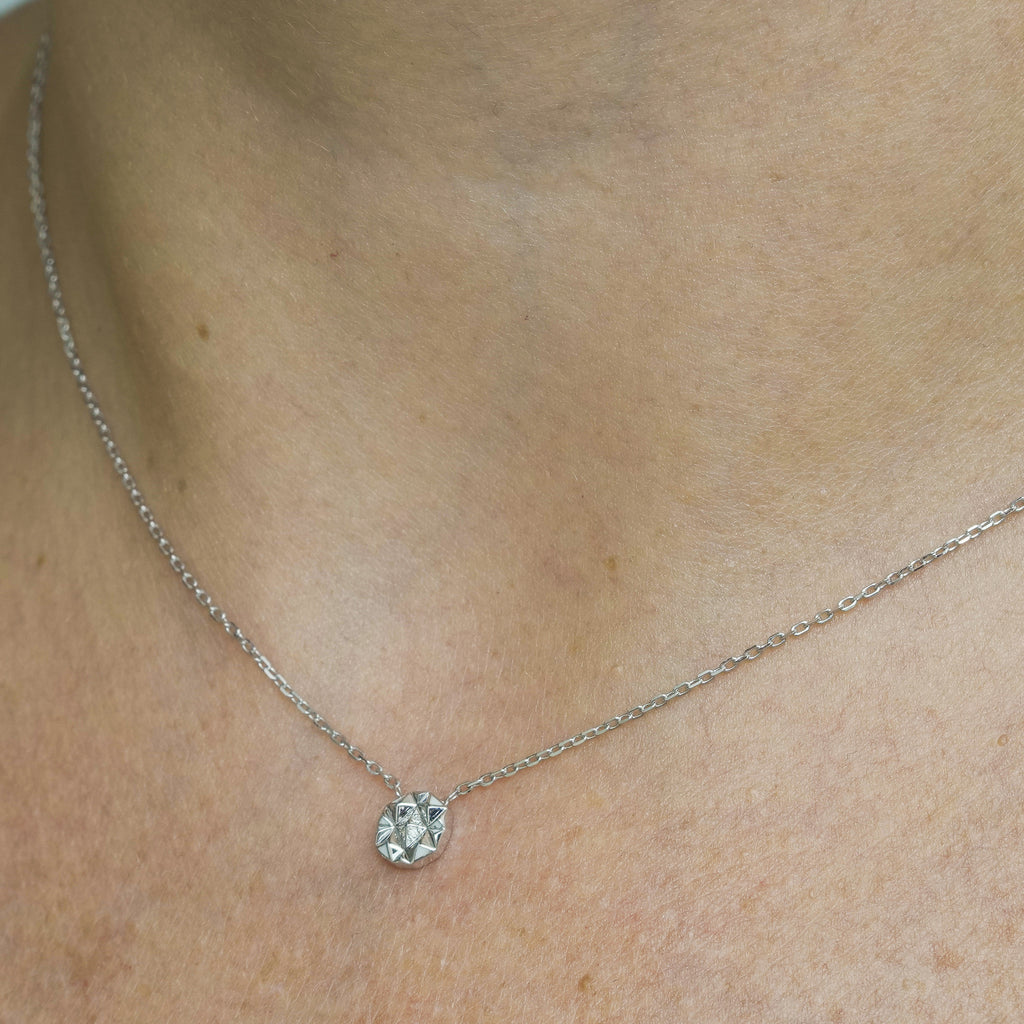 Worn view of Joubijoux gold necklace design showing Slopes Mini pendant layered elegantly on the neckline