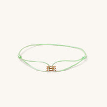 Load image into Gallery viewer, Front view of Kaleido Triad rose gold bracelet with pistachio green adjustable cord and diamond accents