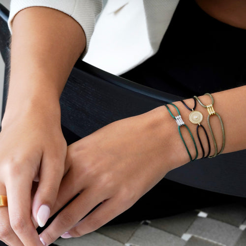 Women wearing Kaleido Triad 18K white gold bracelet with VS diamonds and green adjustable thread