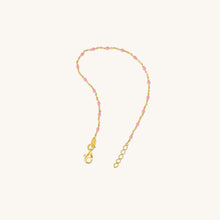 Load image into Gallery viewer, Full length view of 18K gold bracelet with pink enamel raindrop accents and adjustable chain