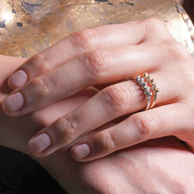 Yellow gold screw design diamond ring worn on finger with modern industrial style