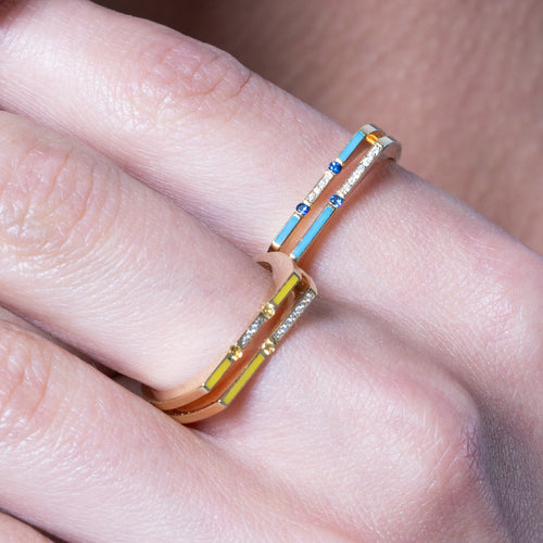 Versa 18K gold ring worn on finger with blue sapphire stones, diamonds, and enamel accents