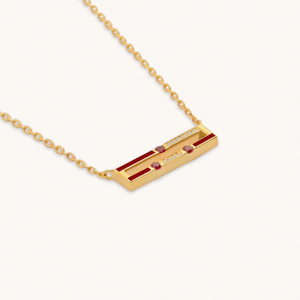 Close-up detail of Versa mini emerald and ruby reversible pendant with diamonds and enamel in 18K gold